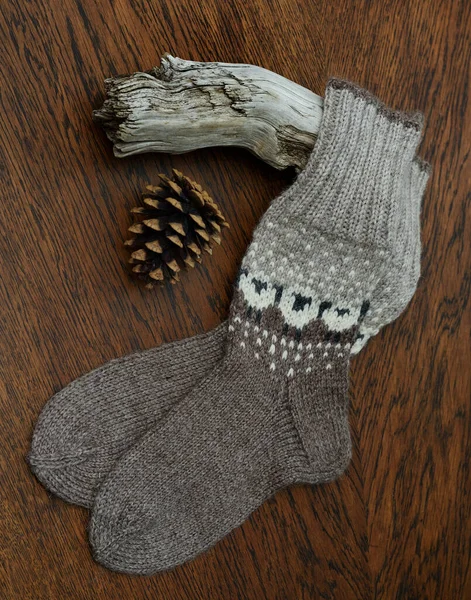 Ein Paar Warme Wollsocken Auf Holzgrund Und Ein Tannenzapfen — Stockfoto