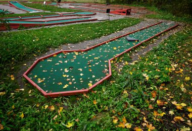 Sonbaharda sarı yapraklarla kaplı mini golf sahası