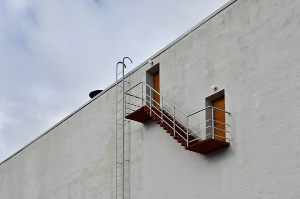 white wall of the house with a staircase and doors