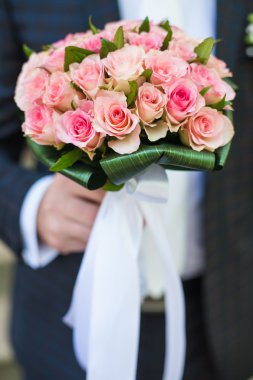 Damat bir buket tutuyor.