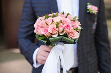 Damat bir buket tutuyor.