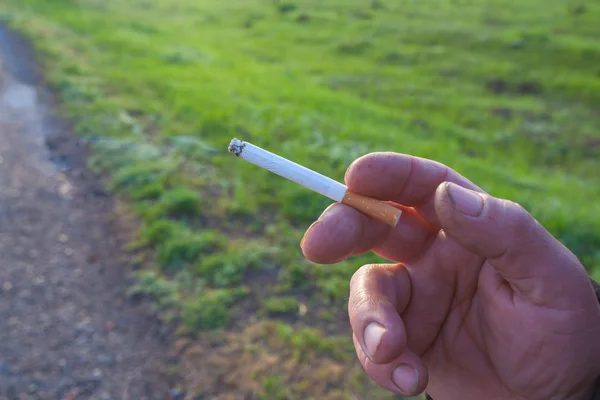 El cigarrillo está en la mano del hombre . — Foto de Stock