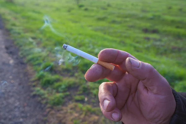 El cigarrillo está en la mano del hombre . —  Fotos de Stock