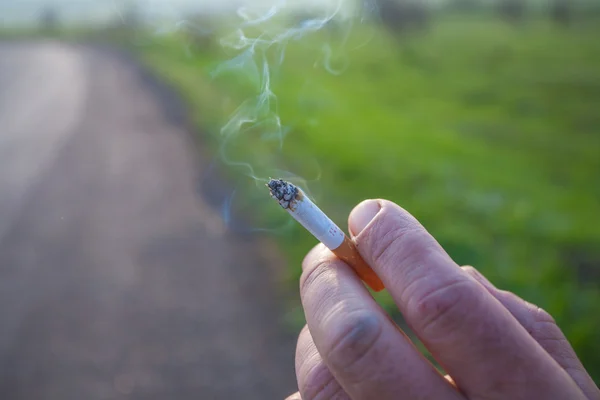 El cigarrillo está en la mano del hombre . —  Fotos de Stock