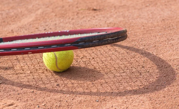 Raqueta de tenis y pelotas en la cancha de barro —  Fotos de Stock