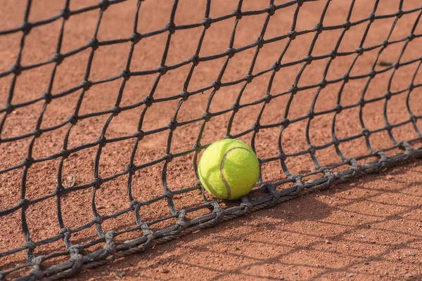 Raqueta de tenis y pelotas en la cancha de barro —  Fotos de Stock