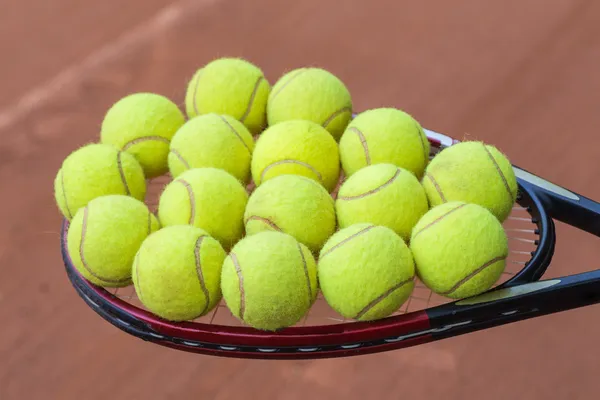 Racchetta da tennis e palline sul campo in terra battuta — Foto Stock