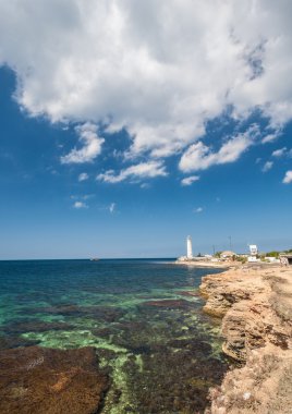 Kaya, mavi gökyüzü ve deniz feneri