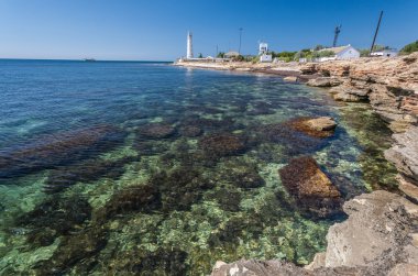 Kaya, mavi gökyüzü ve deniz feneri
