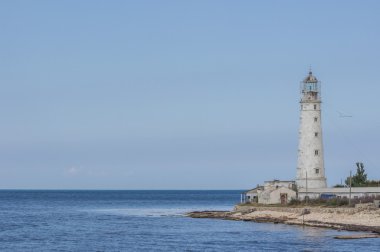 Kaya, mavi gökyüzü ve deniz feneri