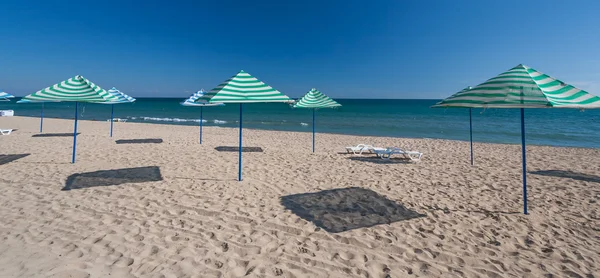 Plaża z leżakami i parasole kryte strzechą — Zdjęcie stockowe