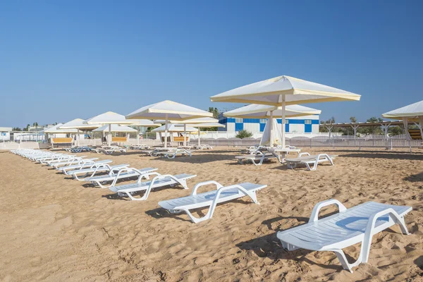 Playa con sillas y sombrillas de paja — Foto de Stock