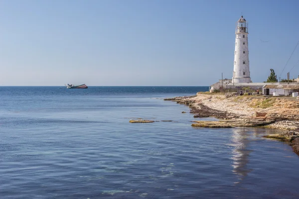 Farol, mar e rocha, céu azul — Fotografia de Stock