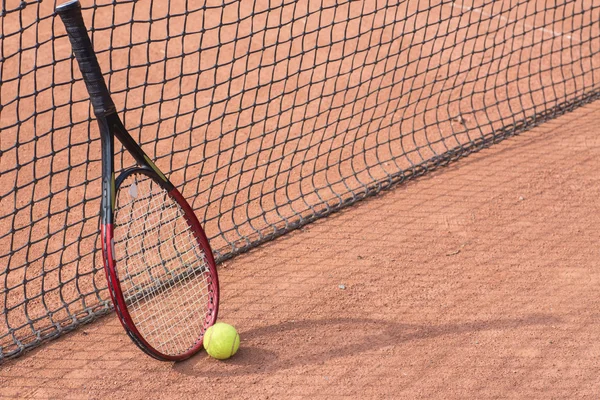 Tennis racket and balls on the clay court — Stock Photo, Image