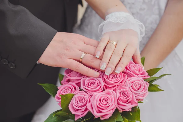 Ręce i pierścienie na Bukiet ślubny — Zdjęcie stockowe