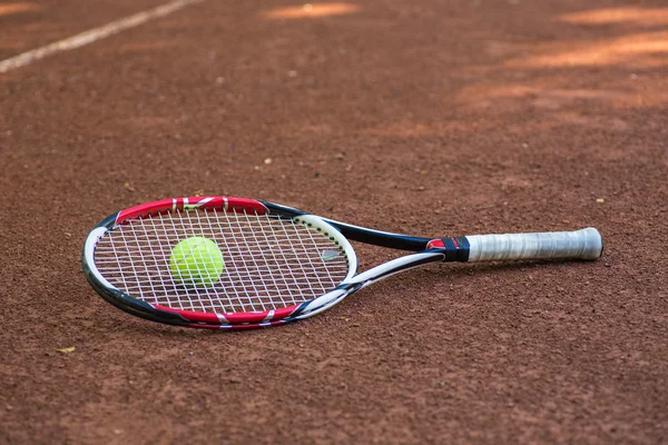 Teniszütő és golyó agyag bíróság — Stock Fotó