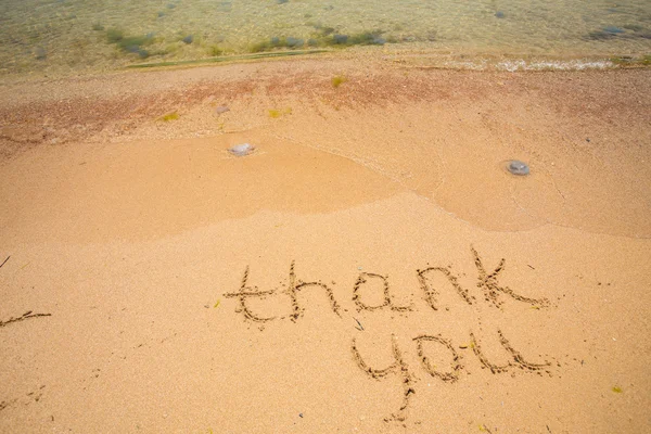 Dank u geschreven in het zand op het strand. — Stockfoto