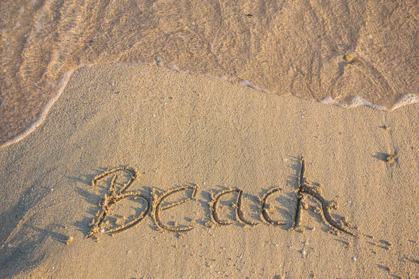 Ordet stranden skrivet på stranden — Stockfoto