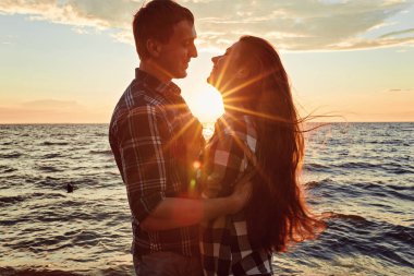 Gün batımında birbirine aşık bir çift burunlarına dokunuyor.