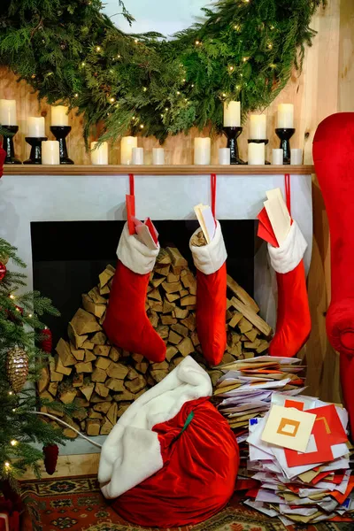 キャンドルクリスマス松の小枝を編んだクリスマスソックスクリスマスツリーとギフトクリスマス暖炉を飾ったクリスマスの暖炉 — ストック写真