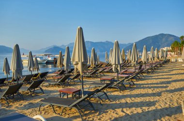 İnsansız kumsal ve güneş pansiyonları, şemsiyeler, palmiye ağaçları, Marmaris, Türkiye,