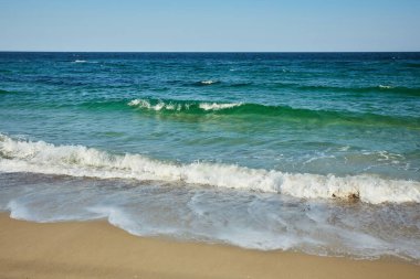 Kumsal ve deniz. Sahil şeridi, açık bir günde küçük dalgalar.
