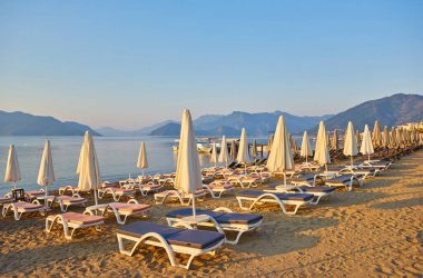 İnsansız kumsal ve güneş pansiyonları, şemsiyeler, palmiye ağaçları, Marmaris, Türkiye,