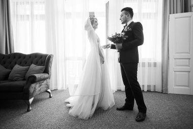 Yeni evli çiftin dans ederken çekilmiş siyah beyaz bir fotoğrafı.