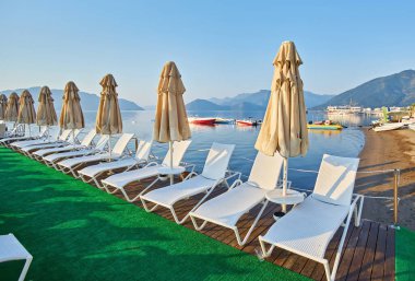 İnsansız kumsal ve güneş pansiyonları, şemsiyeler, palmiye ağaçları, Marmaris, Türkiye,