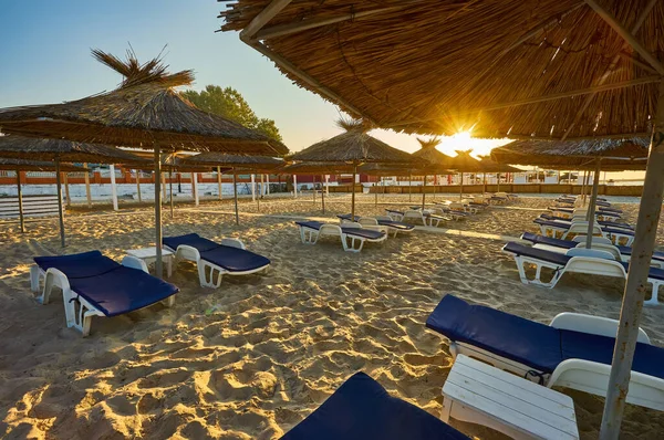Świt Plaży Leżaki Parasole Promieniach Wschodzącego Słońca Plaża Bez Ludzi — Zdjęcie stockowe