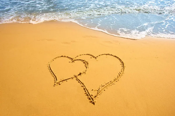 两颗心手写在热带海滩的沙滩上 — 图库照片