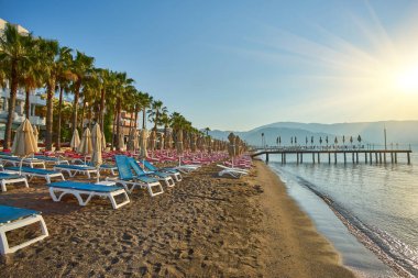 İnsansız kumsal ve güneş pansiyonları, şemsiyeler, palmiye ağaçları, Marmaris, Türkiye,