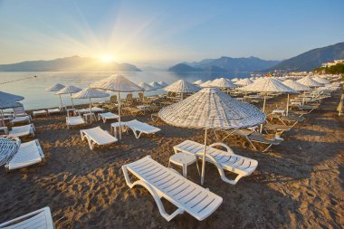 İnsansız kumsal ve güneş pansiyonları, şemsiyeler, palmiye ağaçları, Marmaris, Türkiye,