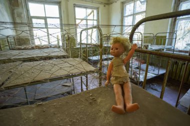 bir oyuncak bebek bebek bir yatakta Pripyat, Çernobil, Ukrayna bina terk edilmiş bir anaokulunda oturma