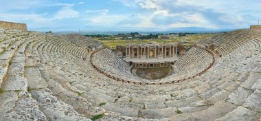 Pamukkale 'deki Hierapolis' teki eski amfi tiyatronun kalıntıları. Türkiye 'de popüler bir turizm merkezi. Panorama antik Greko Roma şehri