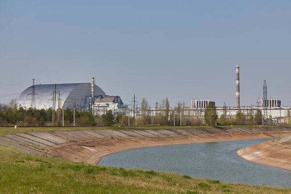 атомные реакторы Чернобыльской электростанции рядом с рекой Припять, 4-й взорванный реактор с саркофагом слева, 3-й реактор справа, зона отчуждения, Украина, Восточная Европа