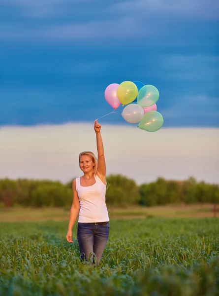 색깔있는 풍선을 초원을 달리고 여자에게 즐거움을 — 스톡 사진