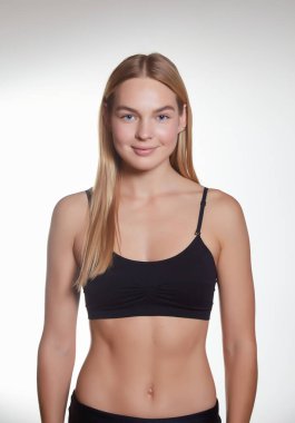 Stüdyo arka planında spor fiziği olan güzel bir kızın stüdyo portresi. Üstteki güzel sarışın ve spor şortlu..