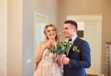 Güzel bir çift gelin ve damat şık iç mekanlarda sarmaş dolaş.