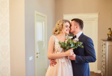 Güzel bir çift gelin ve damat şık iç mekanlarda sarmaş dolaş.