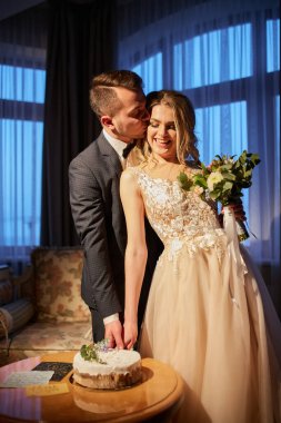 Bir pasta kesme bir düğün, bir masada oturan genç bir çift.