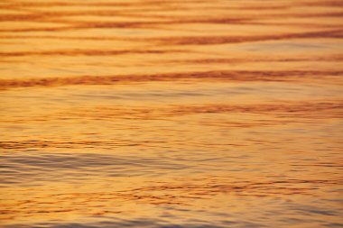 Renkli Okyanus Dalgası. Deniz suyu pürüzsüz. Gün batımı veya gün batımı ve arkaplanda güzel bulutlar