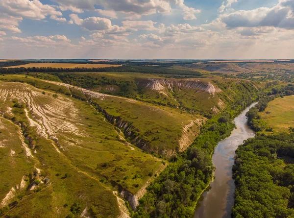 Hava aracı görüntüsü. Yeşil çayırlar arasında geniş bir nehrin kıvrımı. Güneşli yaz günü.