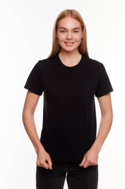 Genç, güzel sarışın kadın, boş siyah tişörtle poz veriyor. Tasarımınız ya da çiziminiz için hazır.