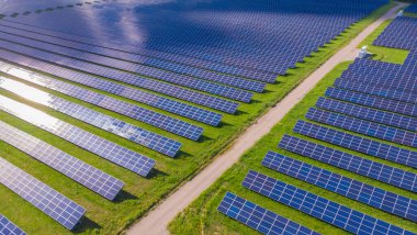 Fotovoltaik güneş sisteminin insansız hava görüntüsü. Metalik mavi güneş panelleri, yenilenebilir ve sürdürülebilir enerji teknolojisi. Alternatif enerji, yeşil arkaplana geç.