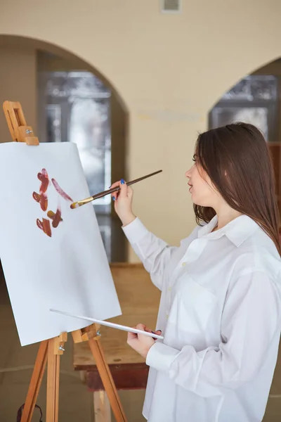 Una Joven Artista Morena Con Una Camisa Blanca Pinta Sobre — Foto de Stock