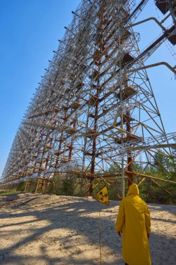 Ukrayna 'daki Çernobil' de askeri gizli nesne anten radarının yanında duran sarı giysili genç adam daha yüksek radyoaktiviteye sahip bir yerde.