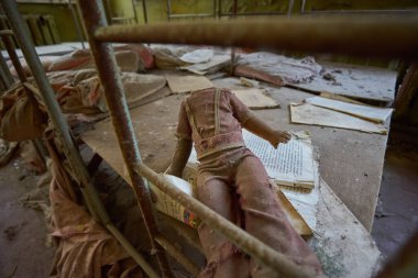 bir oyuncak bebek bebek bir yatakta Pripyat, Çernobil, Ukrayna bina terk edilmiş bir anaokulunda oturma