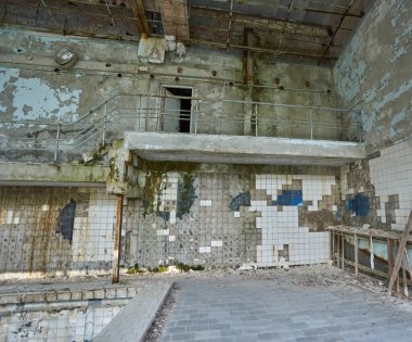 Pripyat 'ta terk edilmiş yüzme havuzu. Radyoaktif bir şehirde spor salonunu yok etti. Sokaklar ağaçlar ve çalılarla kaplı. Tamplin atlanıyor.