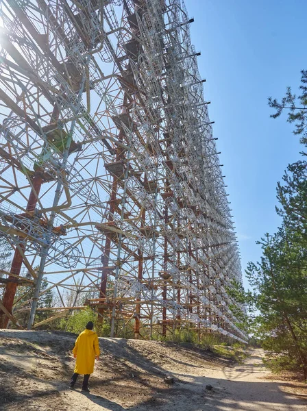 Ukrayna 'daki Çernobil' de askeri gizli nesne anten radarının yanında duran sarı giysili genç adam daha yüksek radyoaktiviteye sahip bir yerde.